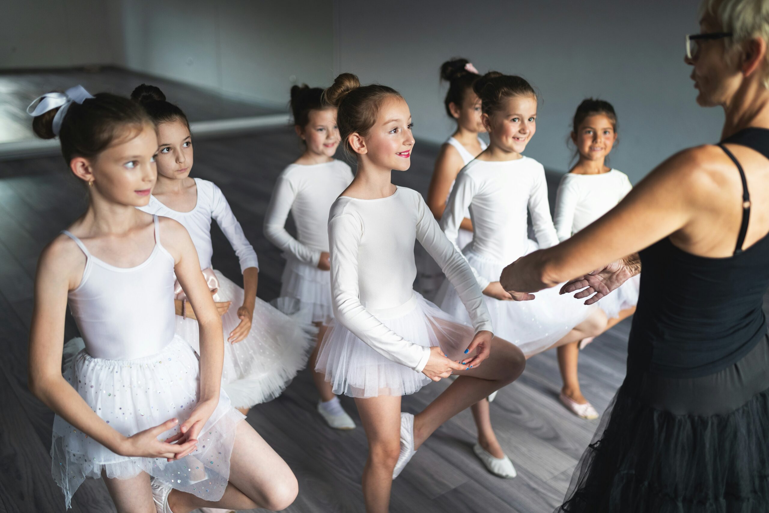Cours de ballets avec des élèves et une professeur de danse dans un studio