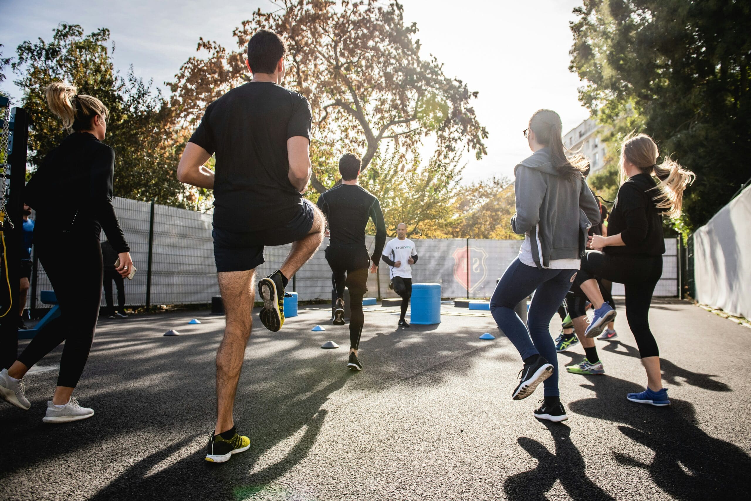 Groupe de personne qui font un cour de fitness à l'extérieur pour s'entrainer