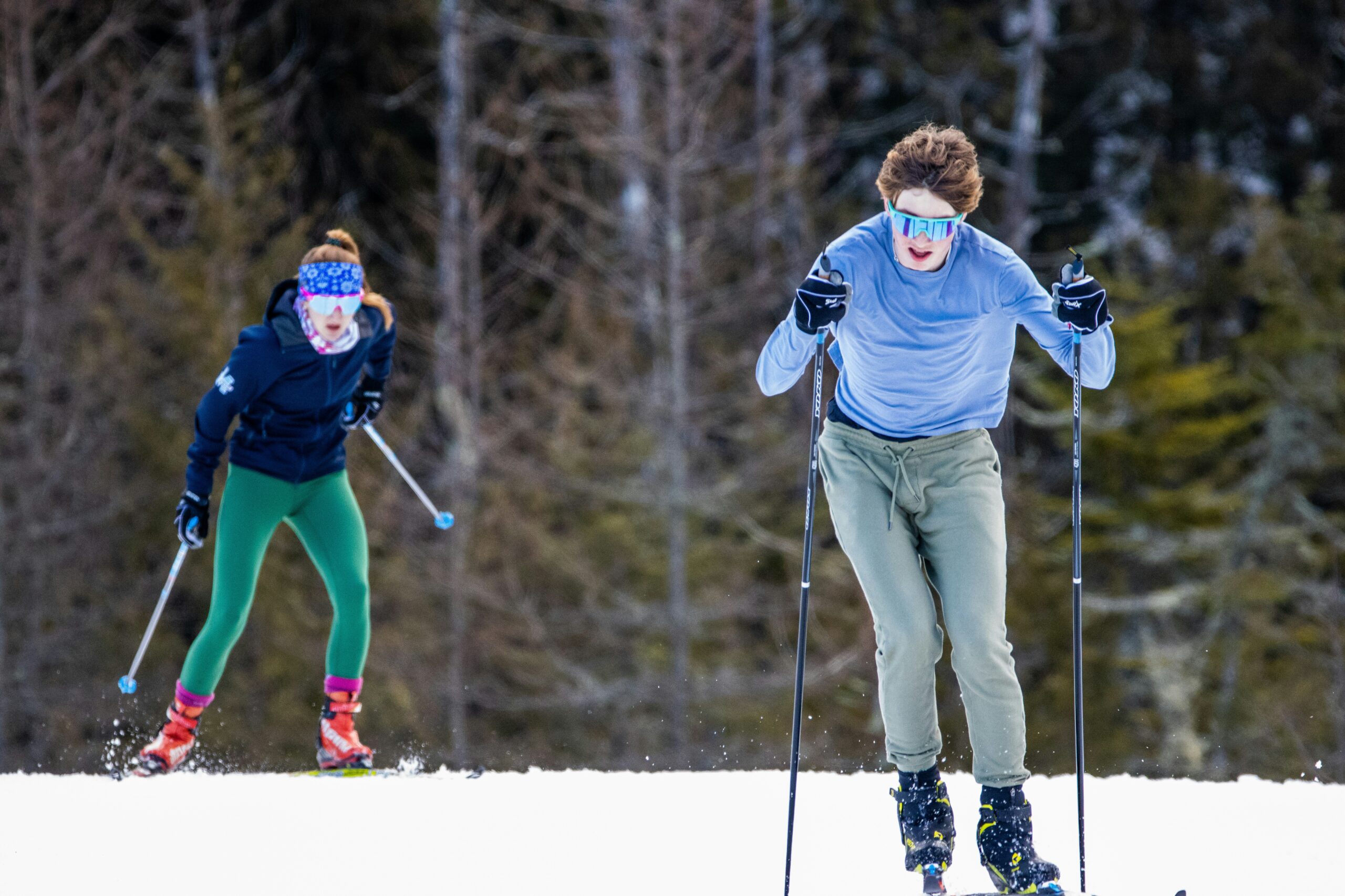 Deux personnes qui font du ski de fond à l'extérieur sur de la neige avec des skis et des batons